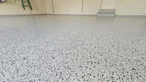 Finished 3 car garage epoxy flooring in North Kansas City MO with gray, black and white flake and a coved wall base