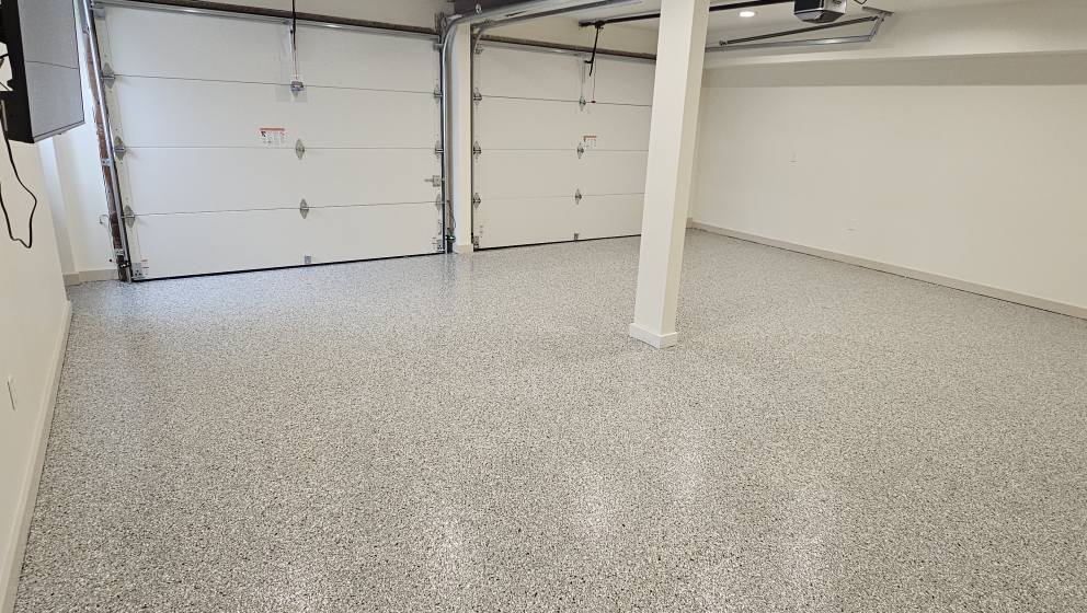Light gray flake epoxy floor in a Kansas City two-car garage with a support column